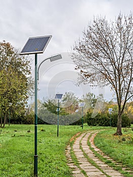 Alley in the park with lighting poles and photovoltaic panel LED lamp lights