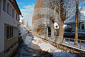 Alley with snow next to the Lyssbach brook in the city of Lyss, small Swiss city