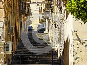 Alley in southern Italy with stairs and cars