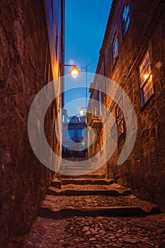 Alley with steps and stone houses at night