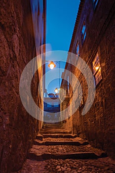 Alley with steps and stone houses at night