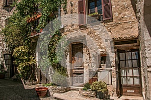 Alley view with wooden doors and plants in Saint-Paul-de-Vence.