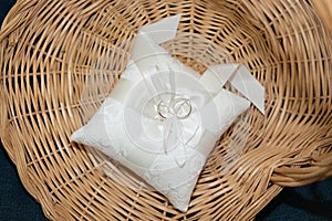 Alliances wedding rings on a pillow in a wicker basket for the wedding couple
