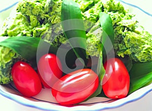 Allium ursinum wild bear garlic butter in a bowl with red tomatoes