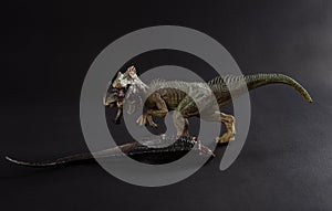 Allosaurus biting a dinosaur body on dark