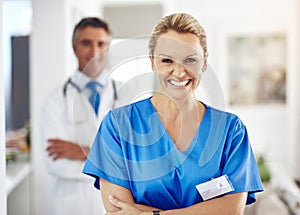 Allow us to take care of you. Portrait of a female nurse standing with her arms crossed in the hospital with a male