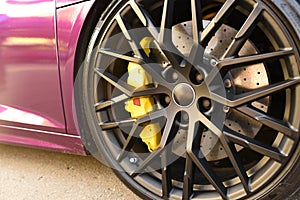 Alloy wheel with calipers and racing brakes of the sport car. Racing brake disc and low profile tyres. Race car test driving.