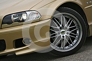 Alloy wheel on golden sports car photo