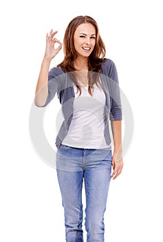 Alls a-okay. Casually dressed woman giving the ok sign while isolated on white.