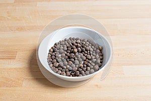 Allspice in a bowl on wood