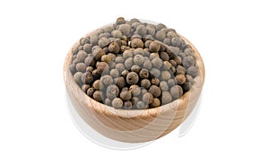 Allspice or Jamaican pepper in wooden bowl isolated on white background. 45 degree view. Spices and food ingredients