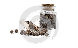 Allspice jamaican pepper in wooden scoop and jar on isolated on white background. front view. spices and food ingredients