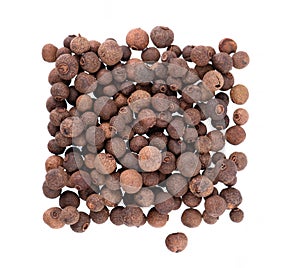 Allspice pile isolated on white background. Jamaican pepper, pimento berry, allspice peppercorns or myrtle pepper. Top