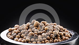 Allspice, pimento, black peppercorn in a stone mortar over black background. Jamaica pepper