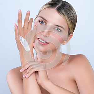 Alluring beautiful woman applying moisturizer cream on her hand for perfect skin