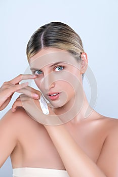 Alluring beautiful woman applying moisturizer cream on her hand for perfect skin