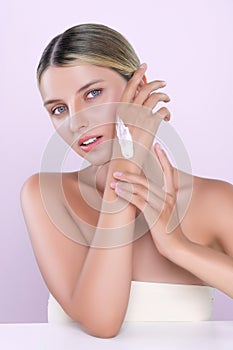 Alluring beautiful woman applying moisturizer cream on her hand for perfect skin