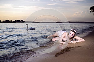 Alluring Sensual Sea Mermaid Blond Woman With Artistic Makeup and Strasses on Face Posing on Ocean Waves with Silver Crown And Net