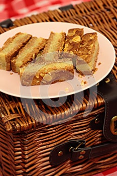 Almond cake slices on a plate with a picnic basket