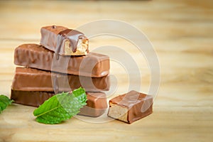 Almond chocolate wafers and a mint leaf on the wooden table