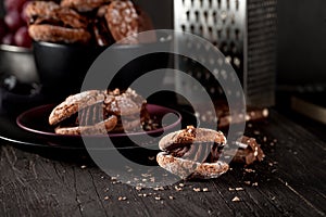 Almond cookies and grapes and chocolate on dark wooden background