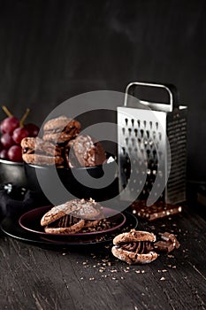 Almond cookies and grapes on dark wooden background