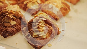 Almond croissants with chocolate on display in a pastry shop. Delicious delicacy and pastries. Slow motion