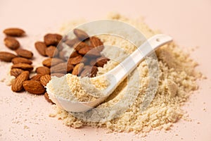 Almond flour and almonds on a beige background
