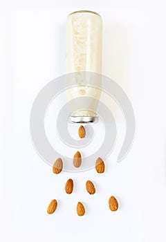 Almond milk and almond seeds over white background, vegetable milk, the concept of proper nutrition raw food vegan