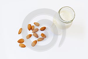 Almond milk and almond seeds over white background, vegetable milk, the concept of proper nutrition raw food vegan