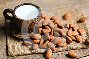 Almond milk and Almonds nuts on on sack background, Delicious sweet almonds on the table, roasted almond nut for healthy food and