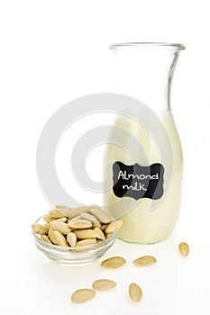 Almond milk and blanched almonds, on white