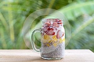Almond milk chia pudding with fresh strawberries and mango in a glass jar mug. Vegan raw breakfast. Chia seeds and fresh cut