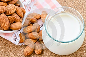 Almond milk in glass with almonds seeds.