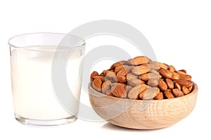 Almond milk in a glass and almonds in a wooden bowl isolated on a white background