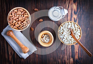 Almond milk, peeled and untreated almonds, ingredients for cooking. Nuts in a wooden bowl. Photo, image.