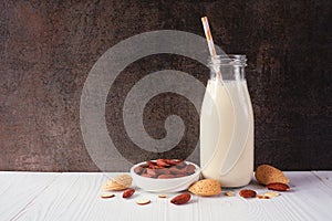 Almond milk in a vintage bottle with ingredients against a dark background