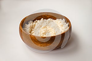 Almond nut crumbs in bamboo wooden bowl on white background isolated