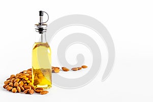 Almond nut oil in glass bottle with almond nuts. Extra virgin essence oil
