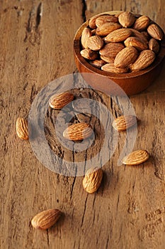 Almond nut in wooden bowl on old wood table background