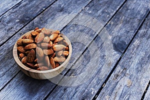 Almond nut in wooden bowl on wood table background, copy space