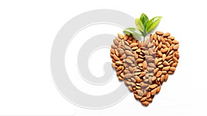 Almond nuts, laid out in the shape of a heart on white background . Jewish holiday Tu Bishvat. Copy space