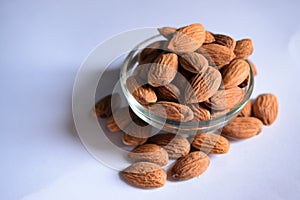 Organic Almond Nuts in a Transparent Glass Bowl On isolated White Background