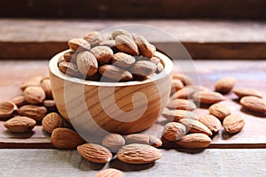 Almond nuts in wooden bowl on rustic background