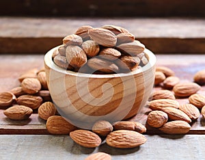 Almond nuts in wooden bowl on rustic background