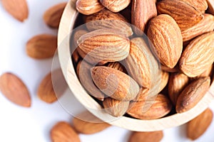 Almond nuts in wooden bowl on white background