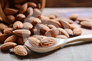 Almond nuts in wooden spoon on rustic background