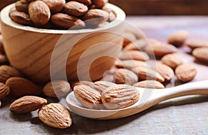 Almond nuts in wooden spoon on rustic background
