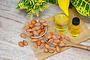 Almond oil and Almonds nuts on table, Delicious sweet almonds oil in glass bottle, roasted almond nut for healthy food and snack