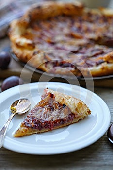 Almond plum cake on puff pastry. Delicious piece of cake.